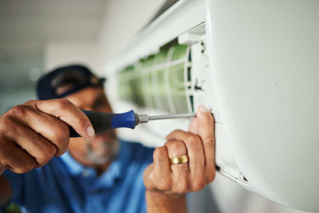 Electrician, hands and air conditioning with man and screwdriver for maintenance, ventilation or power. Engineering, electricity and inspection with closeup of technician for ac repair and contractor.