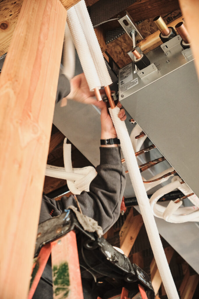Technician securing HVAC unit during installation