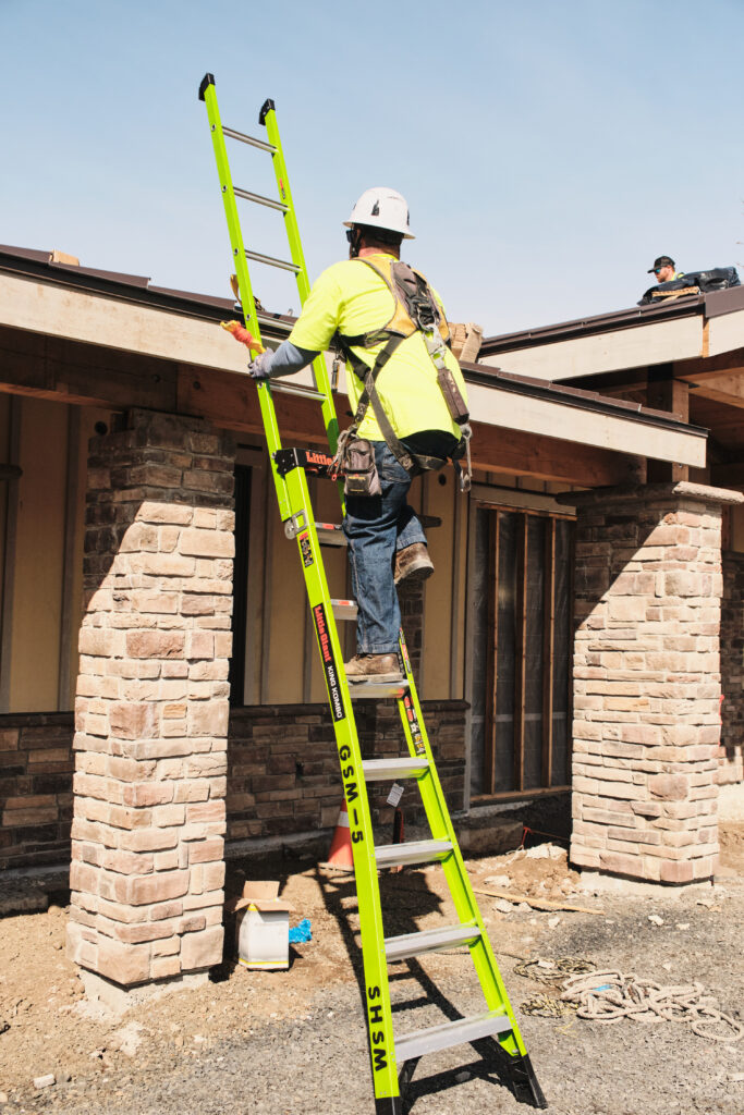 Technician accessing roof via ladder for install work