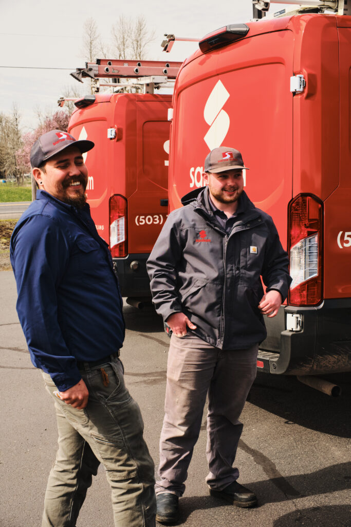 Team members gathered in yard beside trucks