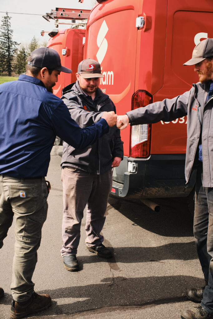 Crew members shaking hands beside service van